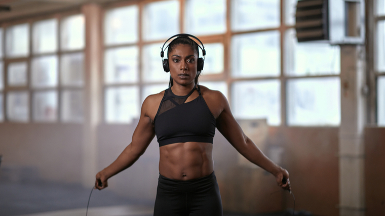 A person jumps rope in the gym while wearing headphones.