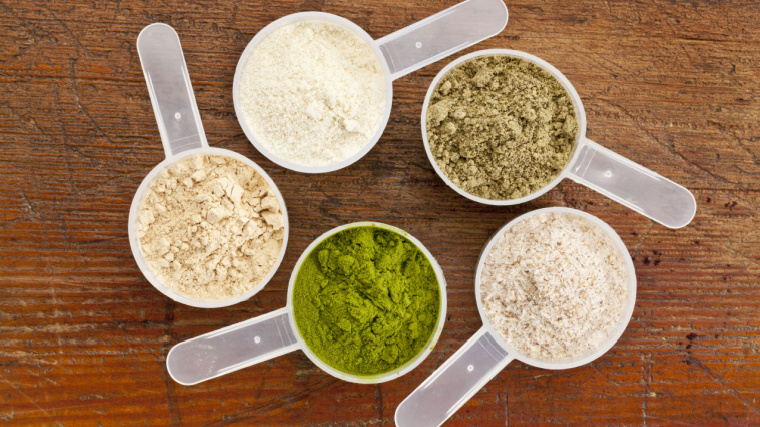 Five scoops of different protein powders.