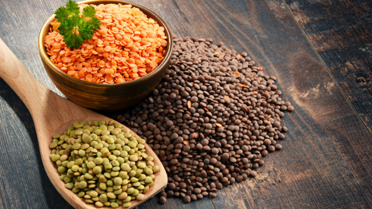 Lentils in a bowl, ladle and on the table.