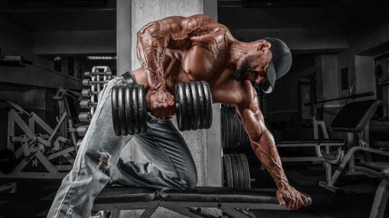 A muscular person doing single-arm dumbbell rows.