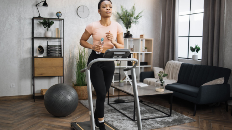 A person running on a treadmill in their living room.