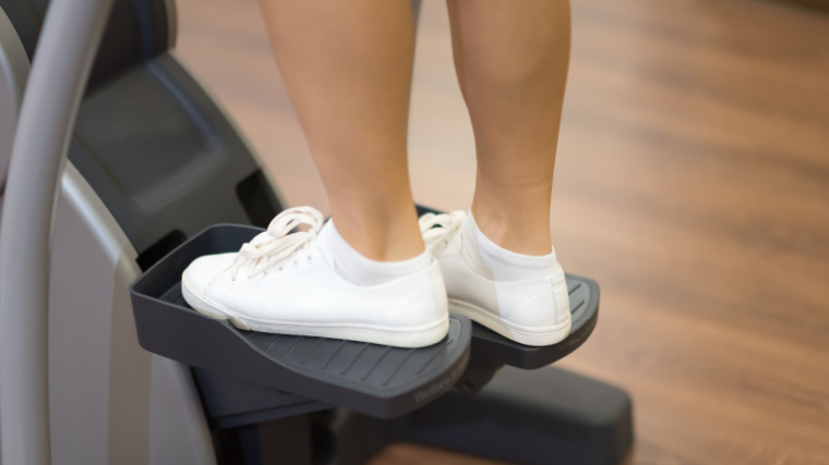 Girl working on the stepper in the gym.