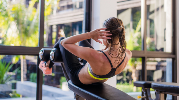 A fit person doing sit up exercises in a hotel gym.