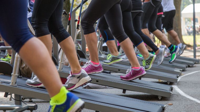 A group working out on treadmills at an incline.