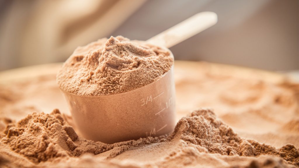 A scoop of protein powder on a bed of protein powder.