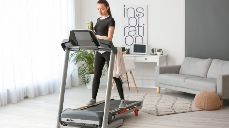 A person programming their treadmill.