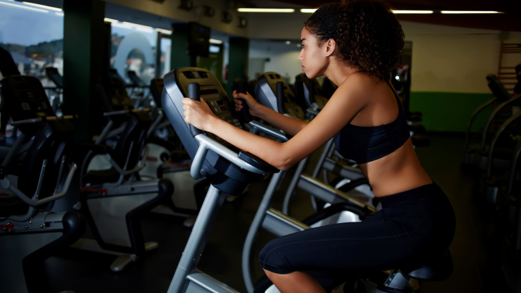 A person on an upright bike in the gym. 