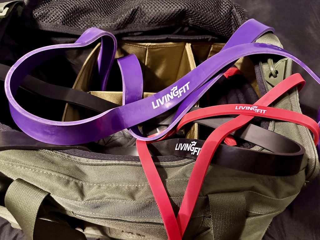 Living.Fit Resistance Bands sitting overtop an open gym bag.