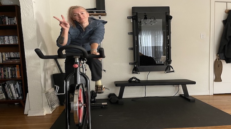 Woman cycling at home in her pajamas